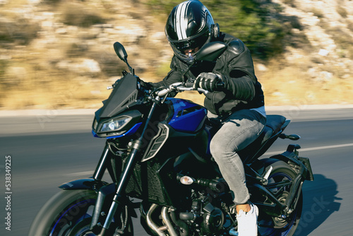 Close up view of a motorcycle rider riding on the highway road with motion blur.