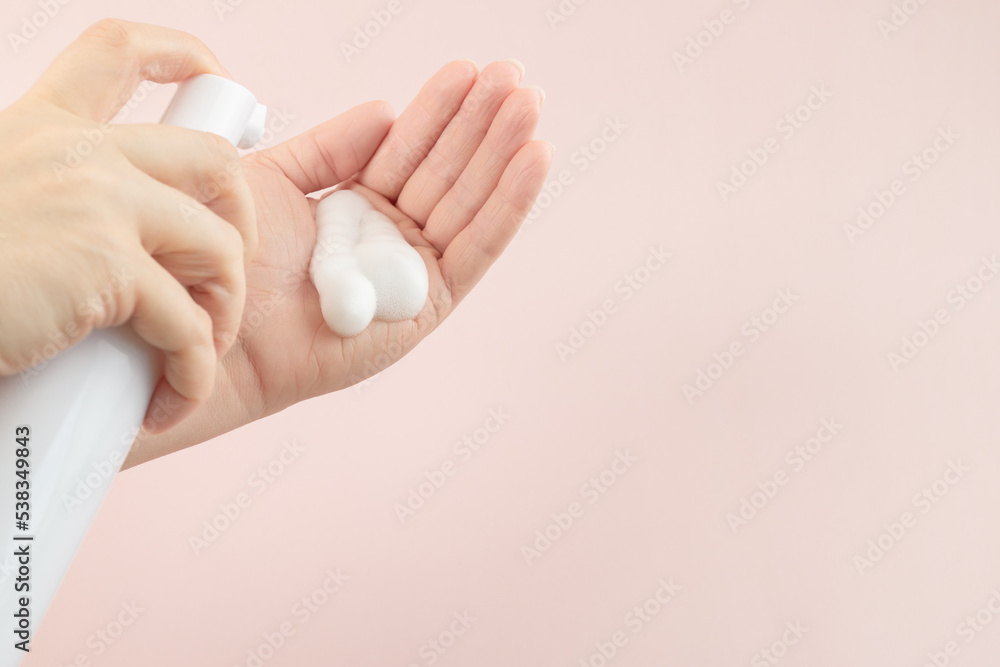 skincare bottle, facewash dispenser in a woman's hand, copy space skincare bottle, facewash dispenser in a woman's hand, copy space