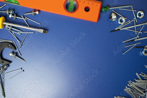 repair tools, screwdrivers, level, nails on a blue background, copy space