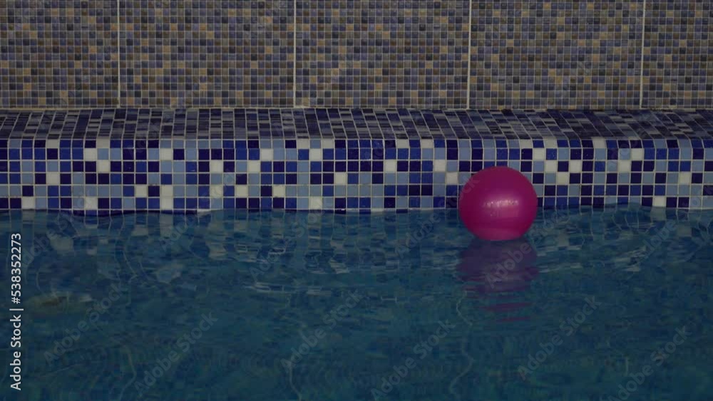 Vidéo Stock Pink beach ball falls in a water and floats in a indoors ...
