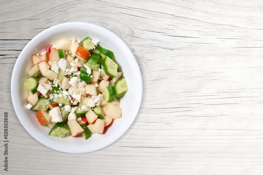 Fresh Mediterranean Salad on White Wood Background with Copy Space