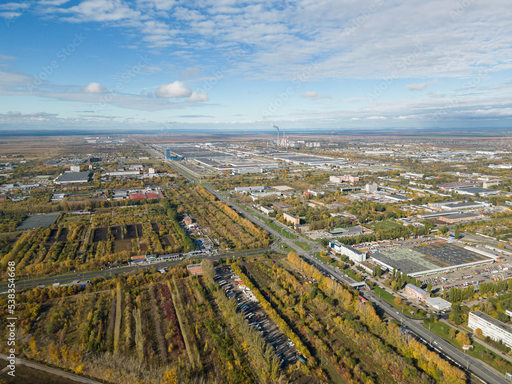 Aerial panorama of the city and industrial area. The city in the warm light of the sunrise. Bird's-eye view. Aerial photography. A picture from a drone.