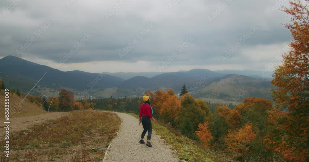 young woman traveler in the mountains enjoying the cool autumn weather and fooling around. autumn cold weather. Generation Z travel young woman traveler in the mountains enjoying the cool autumn weather and fooling around. autumn cold weather. Generation Z travel