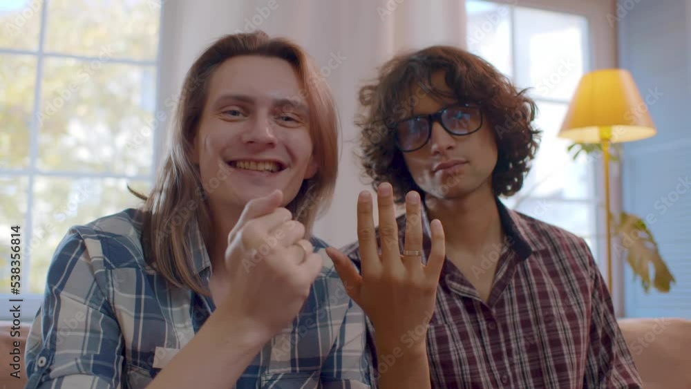 Happy gay couple showing engagement rings on hands enjoying romantic celebration. Realtime Happy gay couple showing engagement rings on hands enjoying romantic celebration. Realtime