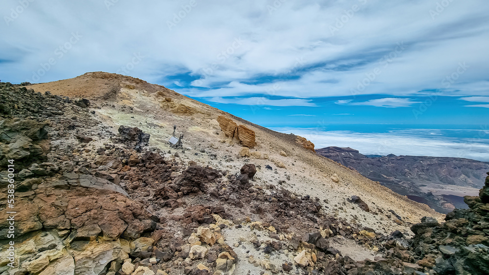 Panoramic view on volcanic desert terrain near summit of volcano Pico del Teide, Mount Teide National Park, Tenerife, Canary Islands, Spain, Europe. Solidified lava, ash, pumice. Clouds accumulating