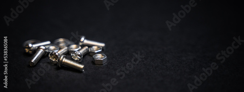 Banner of close up crafts of bolts, screws, nuts, washers, mechanical parts falling and bouncing in slow motion. black background. precision work. Work as a carpenter. Joinery and construction work.