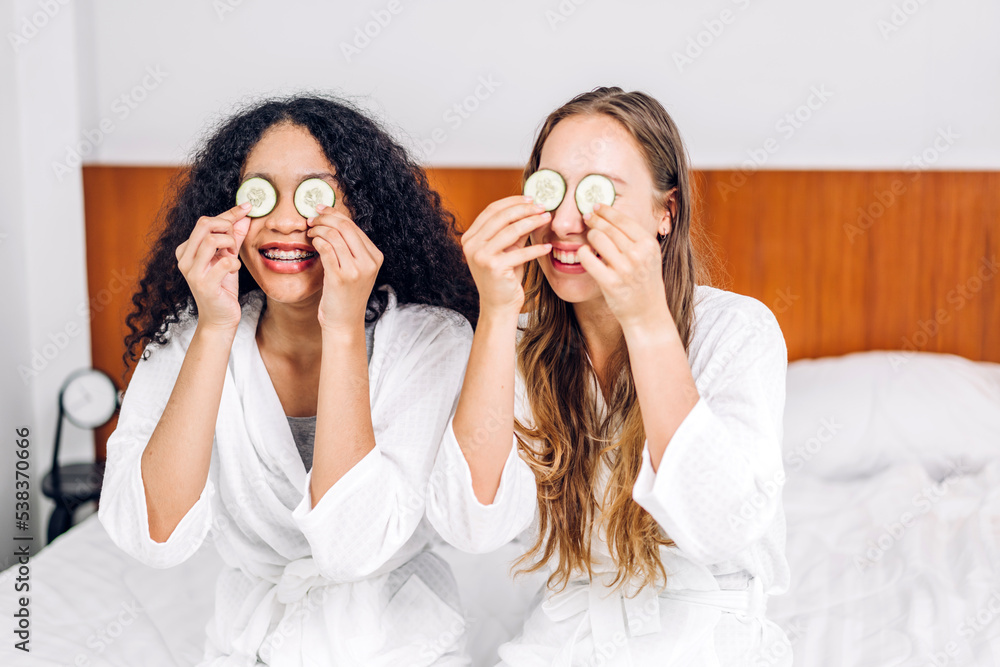 Portrait of smiling of happy beauty woman friend clean fresh healthy white skin spa treatment.african girl mask face with cucumber facial mask in the room.beauty and spa.perfect fresh skin Portrait of smiling of happy beauty woman friend clean fresh healthy white skin spa treatment.african girl mask face with cucumber facial mask in the room.beauty and spa.perfect fresh skin