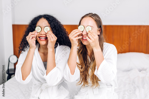 Portrait of smiling of happy beauty woman friend clean fresh healthy white skin spa treatment.african girl mask face with cucumber facial mask in the room.beauty and spa.perfect fresh skin