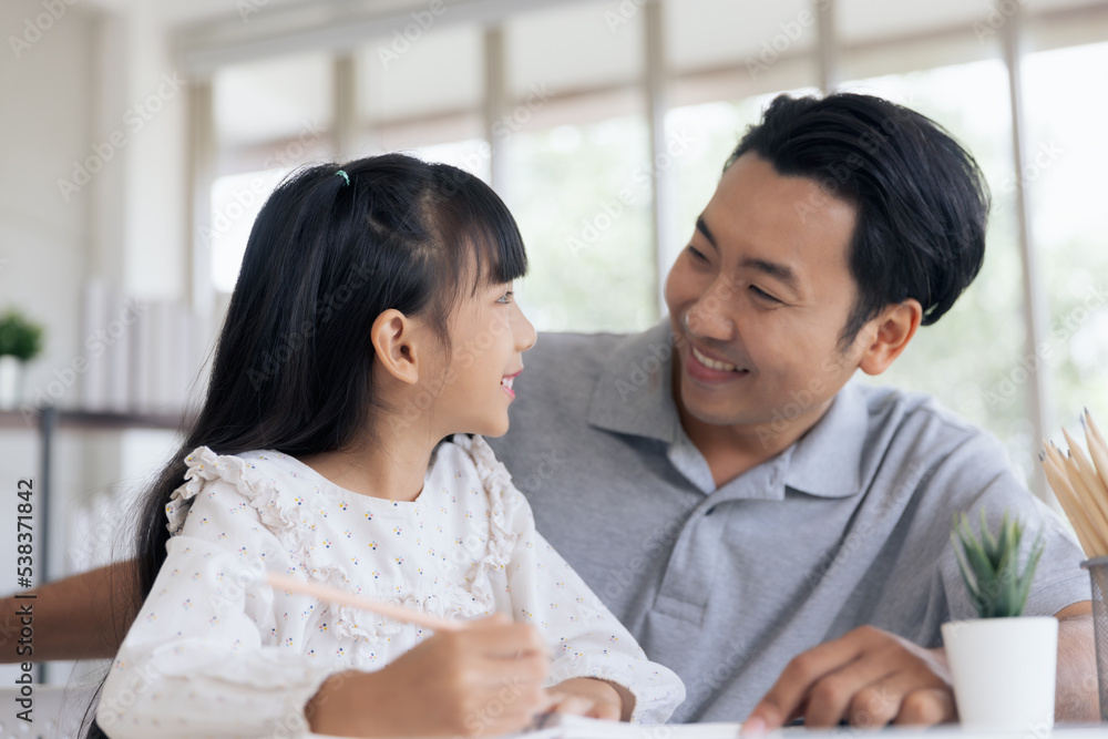 Attractive asian father teaching little child daughter learning studying doing homework at home, Family quality time and e-learning education concept Attractive asian father teaching little child daughter learning studying doing homework at home, Family quality time and e-learning education concept