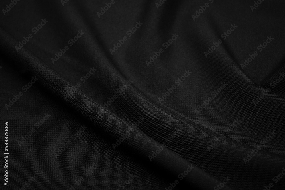 Texture of dark black fabric closeup. Low key photo. Plexus threads. Clothing industry. Abstract background. Black textile waves. Black cloth background