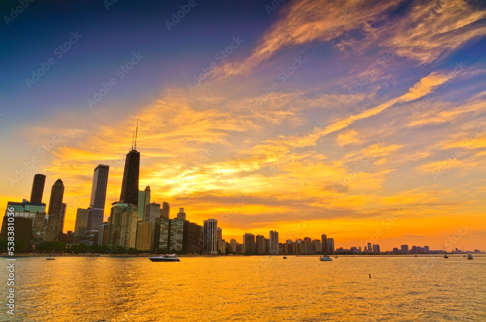 View of Chicago skyline from the shore of Lake Michigan at sunset.