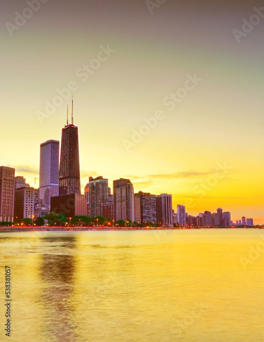 View of Chicago skyline from the shore of Lake Michigan at sunset. © Javen