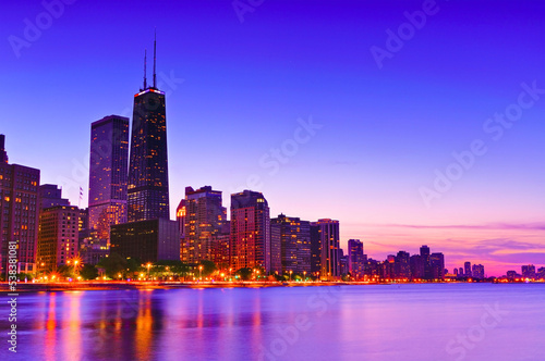 View of Chicago skyline from the shore of Lake Michigan at dusk.