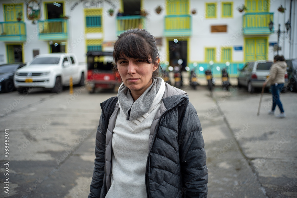 Young Woman wearing Winter Jacket Looks at the Camera in Salento Streets, Colombia
