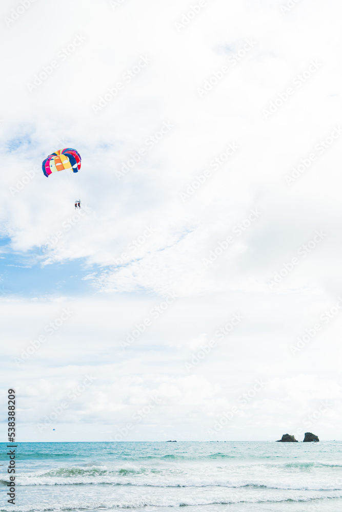 Unrecognizable couple practicing aquatic parachute on a cloudy day. Unrecognizable couple practicing aquatic parachute on a cloudy day.