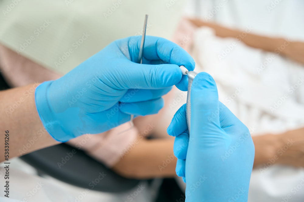 Dental specialist with drill in arms in stomatology center Dental specialist with drill in arms in stomatology center