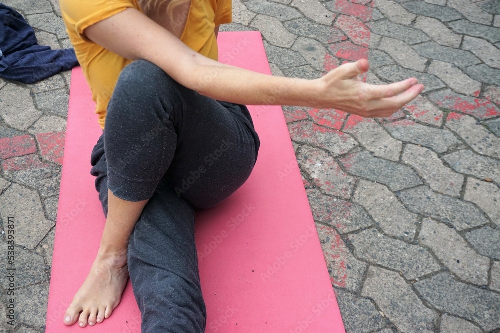 Φωτογραφία Junge Frau in grauer Hose und gelbem T-Shirt sitzt auf roter Gummimatte und grau