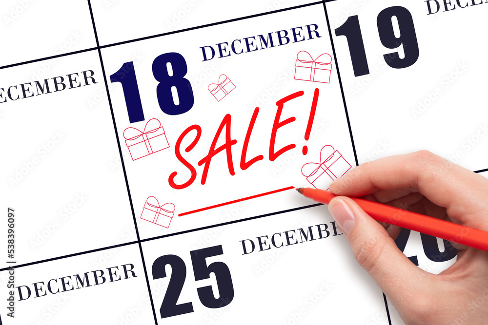 Hand writing text SALE and drawing gift boxes on calendar date December 18. Shopping Reminder Hand writing text SALE and drawing gift boxes on calendar date December 18. Shopping Reminder