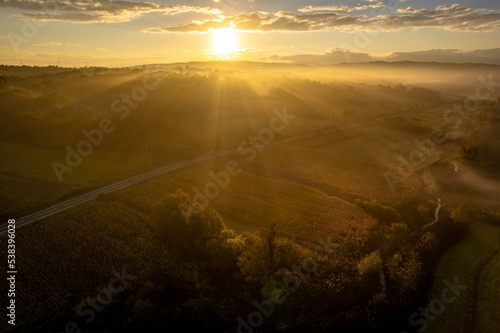 Aerial colorful view of foggy autumn morning over hills and forests, in Soceni village, Romania. Captured from above, with a drone. © Oană Liviu