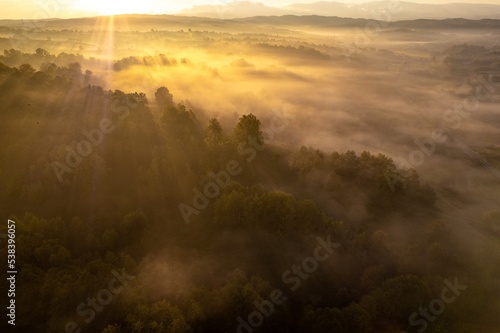 Aerial colorful view of foggy autumn morning over hills and forests  in Soceni village  Romania. Captured from above  with a drone.