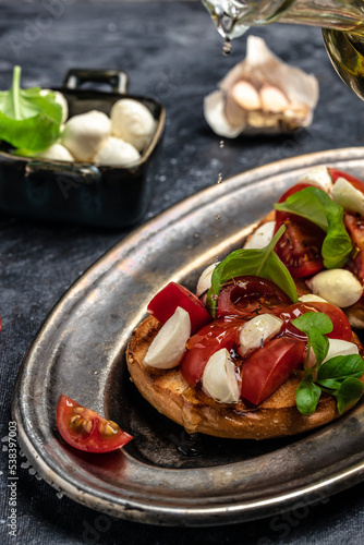 Open sandwiches with cherry tomatoes, mini mozzarella, fresh basil leaves, caprese on bread, Traditional italian appetizer or snack, antipasto. banner, menu, recipe place for text, top view