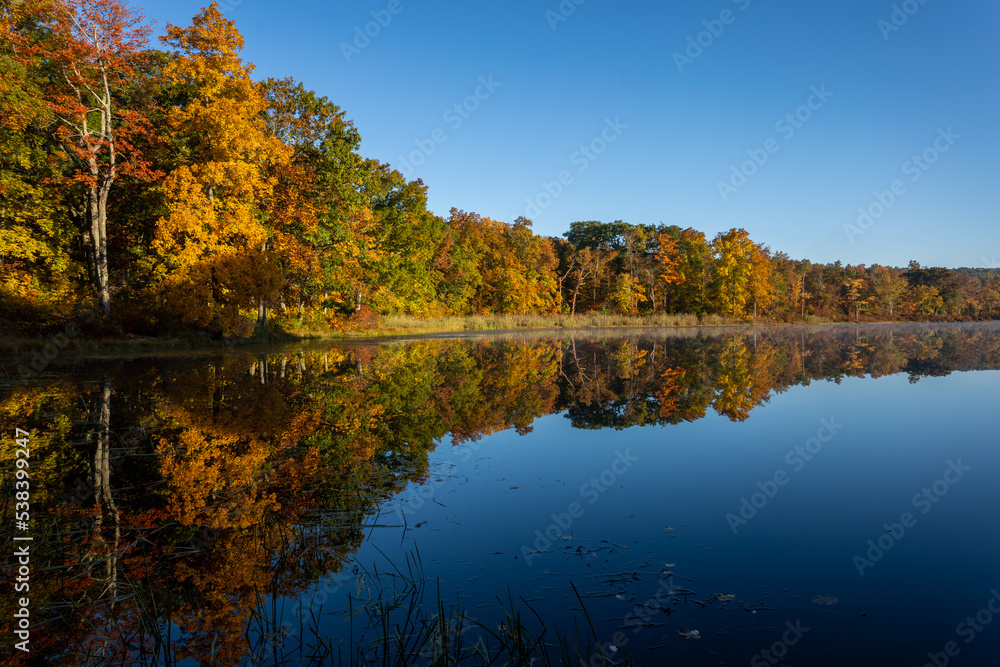 Sawmill Lake in High Point State Park, NJ, on a quiet and calm Autumn morning surrounded by brilliant fall foliage