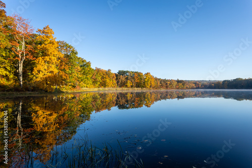 Fototapeta Naklejka Na Ścianę i Meble -  Sawmill Lake in High Point State Park, NJ, on a quiet and calm Autumn morning surrounded by brilliant fall foliage