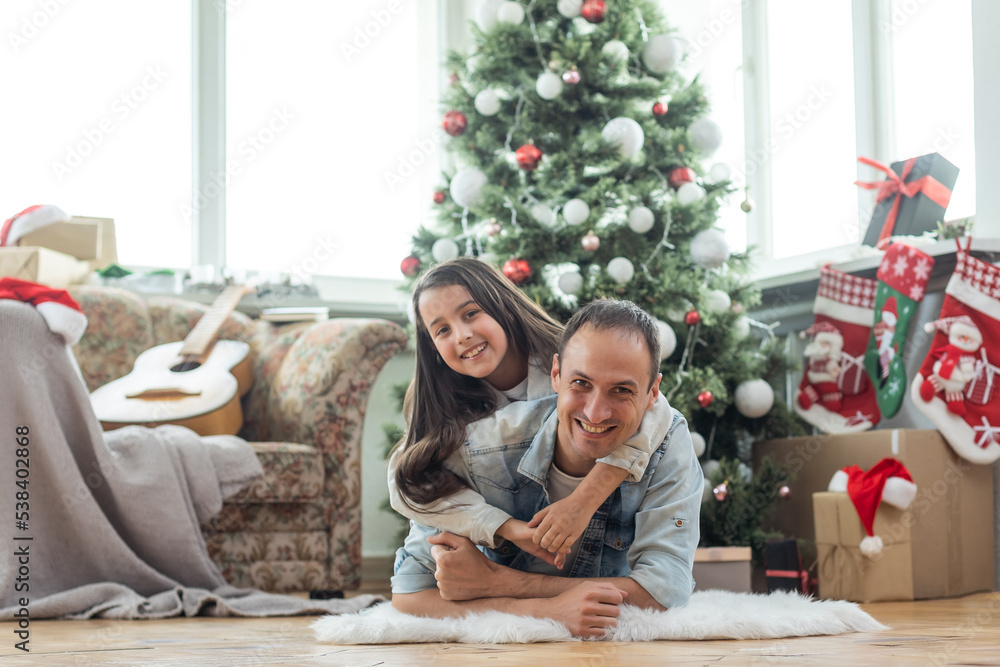 Happy father and his little daughter decorating the Christmas tree at home Happy father and his little daughter decorating the Christmas tree at home