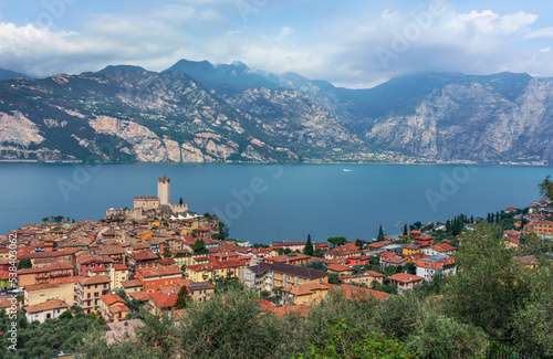 Top view to old town Malcesine with ancient tower and fortress at Garda lake  Veneto region  Italy  mountains in the background. 