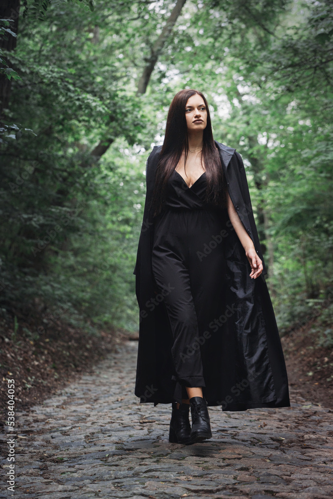 A beautiful woman walks alone through a dense forest A beautiful woman walks alone through a dense forest