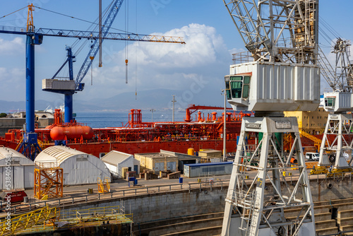 Gibraltar, British Overseas Territory. Harbor and the Bay of Gibraltar with its colorful rail cranes, containers, ships and boats.