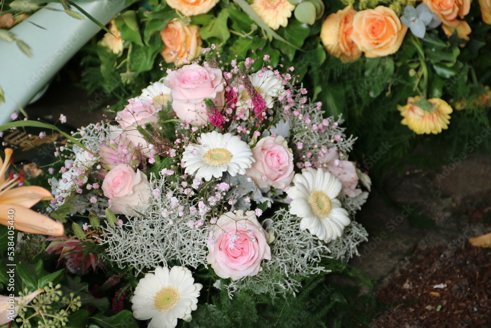 Gesteck mit rosa Blumen nach Beerdigung auf dem Friedhof