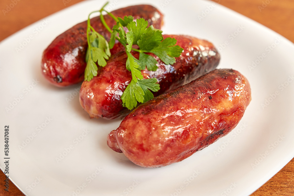 Fried sausages on a white plate. Fried sausages on a white plate.