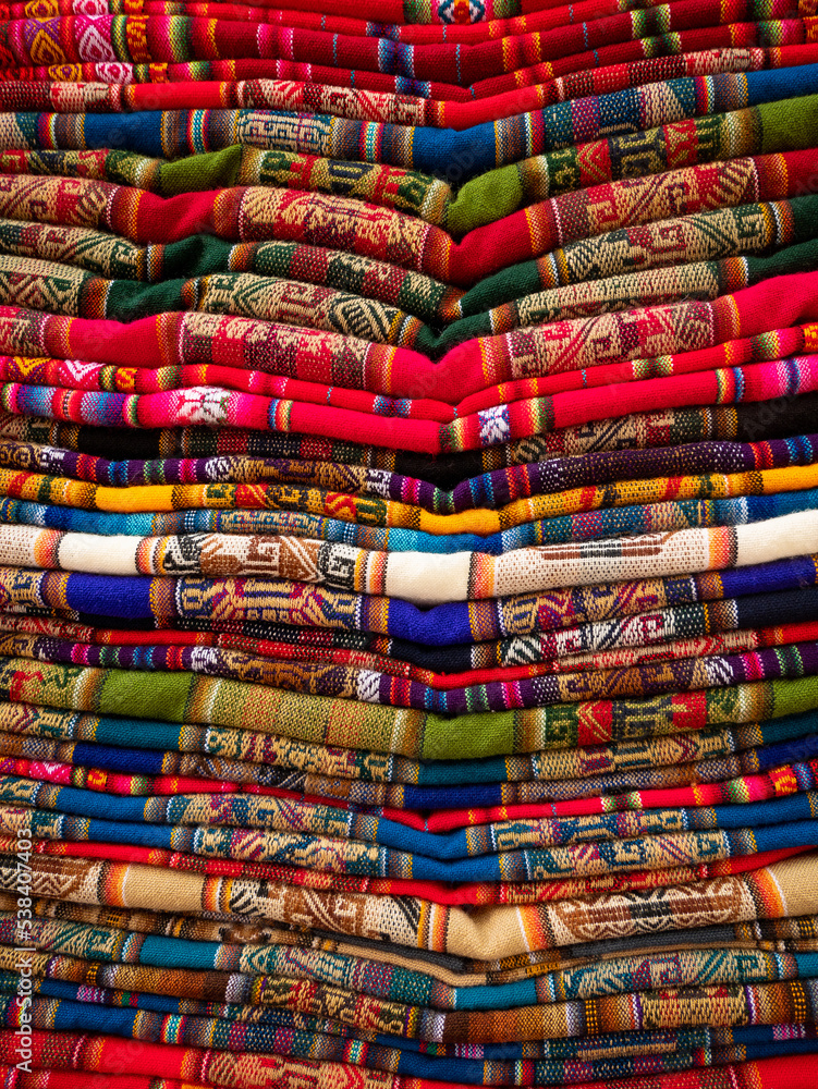 Several Aguayo Fabrics of Different Colors Stacked on Top of each Other