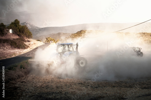 A group of tractors perform a firebreak.
 photo