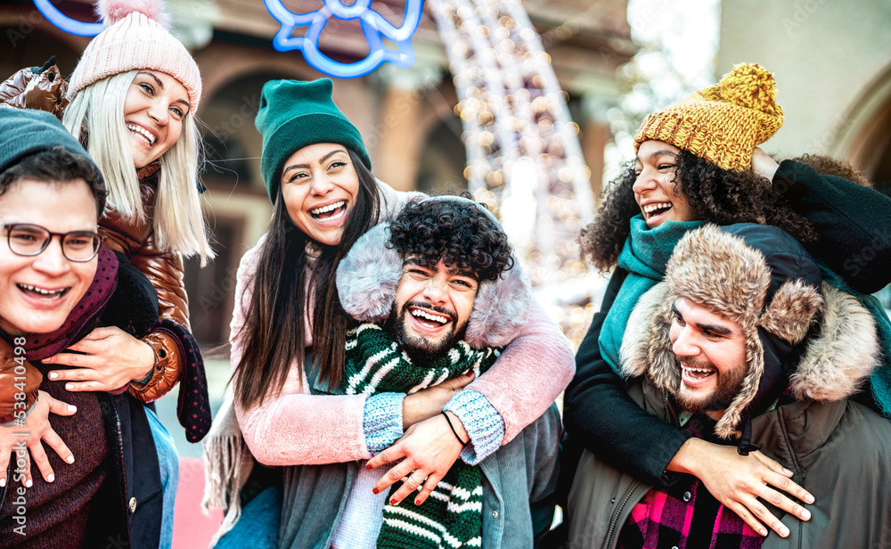 Happy international friends walking at winter travel location on piggy back move - Everyday life style concept with happy guys and girls having fun together outside - Bright contrast filter Happy international friends walking at winter travel location on piggy back move - Everyday life style concept with happy guys and girls having fun together outside - Bright contrast filter