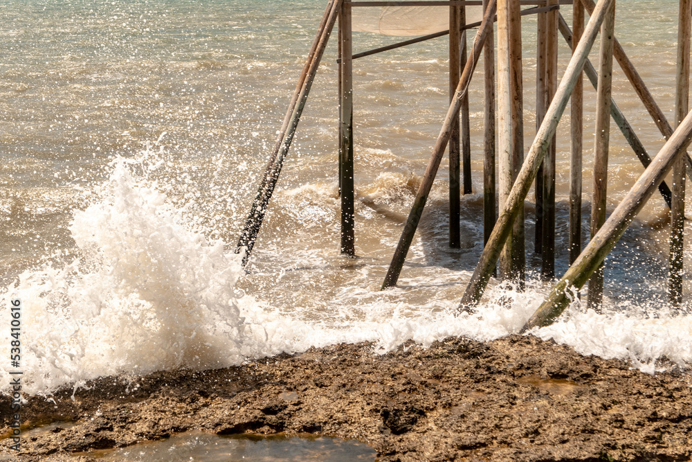 water flowing into the water with big waves and wood house water flowing into the water with big waves and wood house