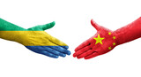 Handshake between China and Gabon flags painted on hands, isolated transparent image.
