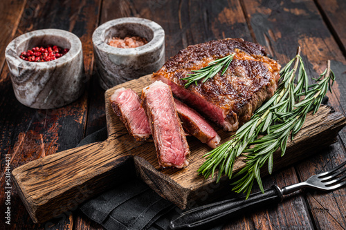 Fototapeta Sliced and Grilled rib eye steak, rib-eye beef marbled meat on a wooden board