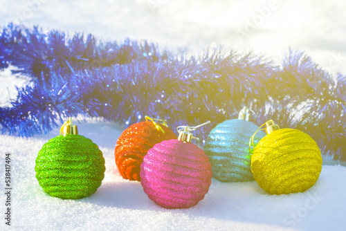 closeup heap of christmas toys lie on snow in sunlight, natural seasonal holiday background