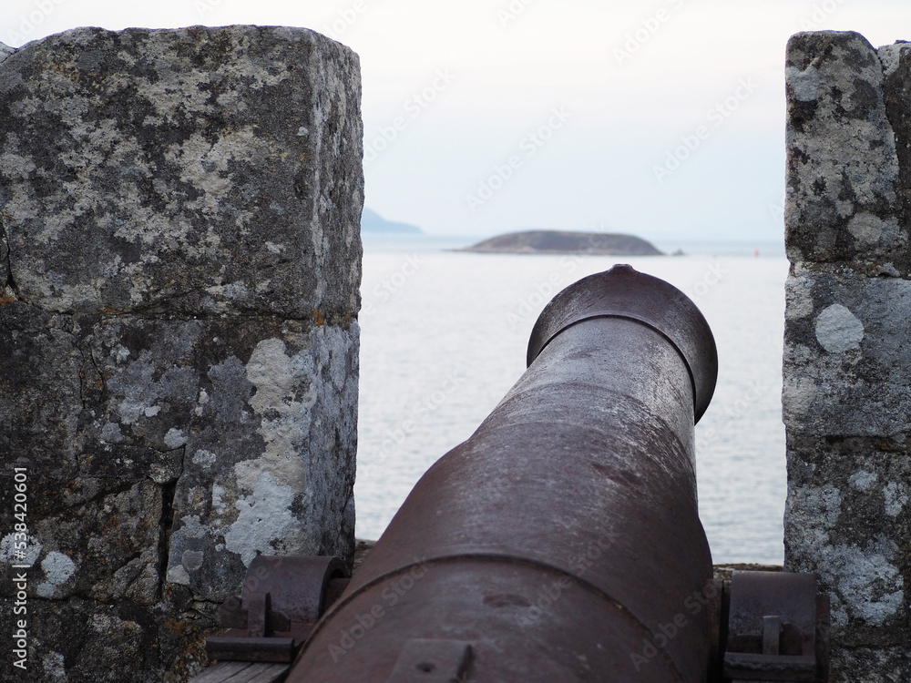 spanish ancient schooner cannon with island in the background