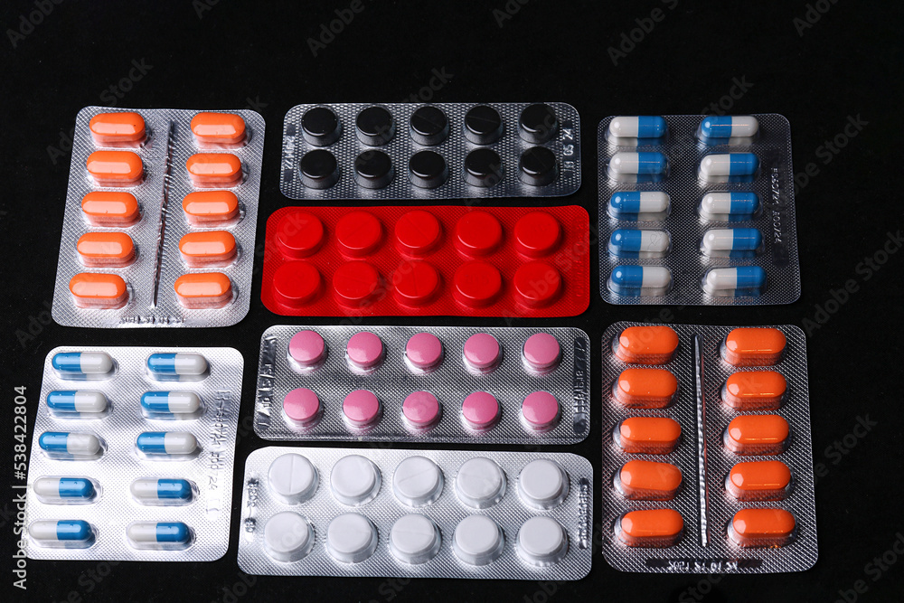 Set of medical tablets and pills in pharmaceutical blister pack on black Set of medical tablets and pills in pharmaceutical blister pack on black