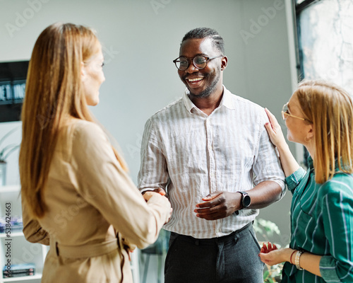 young business people meeting office handshake hand shake shaking hands teamwork group contract agreement black happy smiling success partnership introduction greeting businessman man introducing