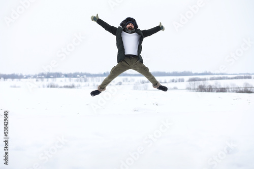 Bearded man in the winter woods. Attractive happy young man with beard walk in the park.