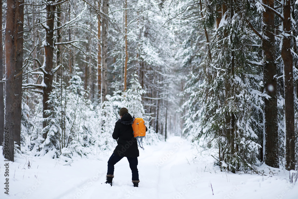 Hiking winter landscape. A man with a backpack travels in winter. A man in a snowy field.