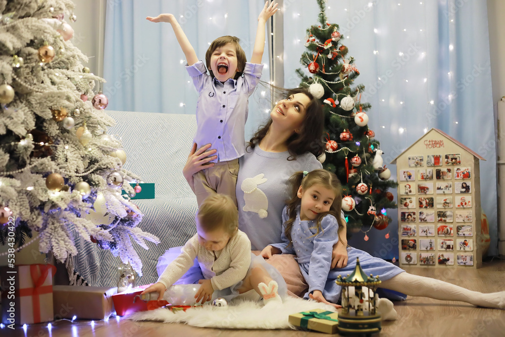 New Years Eve. The house is decorated for the holiday. Christmas tree with a garland and a family with gifts and a surprise. New Years Eve. The house is decorated for the holiday. Christmas tree with a garland and a family with gifts and a surprise.