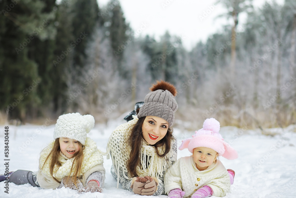 Happy family playing and laughing in winter outdoors in the snow. City park winter day.