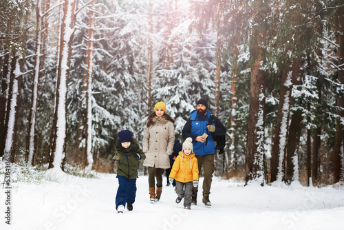 Happy family playing and laughing in winter outdoors in the snow. City park winter day.