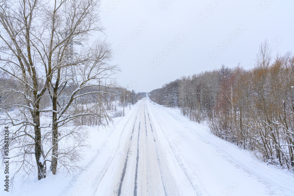 Snowy winter road in a mountain forest.