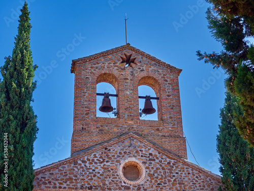 Stone and brick bell tower with two bells of the church  Parroquia de Nuestra Señora del Buen Consejo y San Anton. Puerto Lapice, village in the route of Don Quixote, province of Ciudad Real, Spain photo